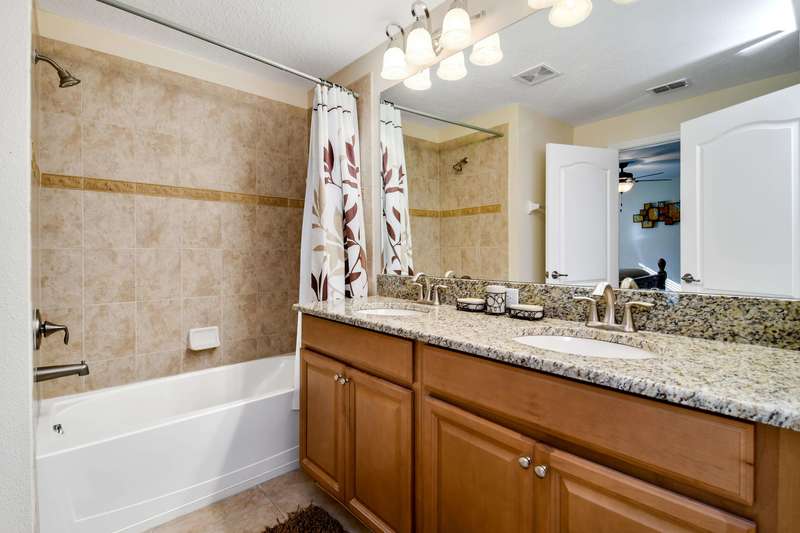 The master bathroom provides ceramic tiled floors, a mirrored vanity with granite counter top and his 'n' hers basins, a bath-tub with step-in shower, and a private toilet.