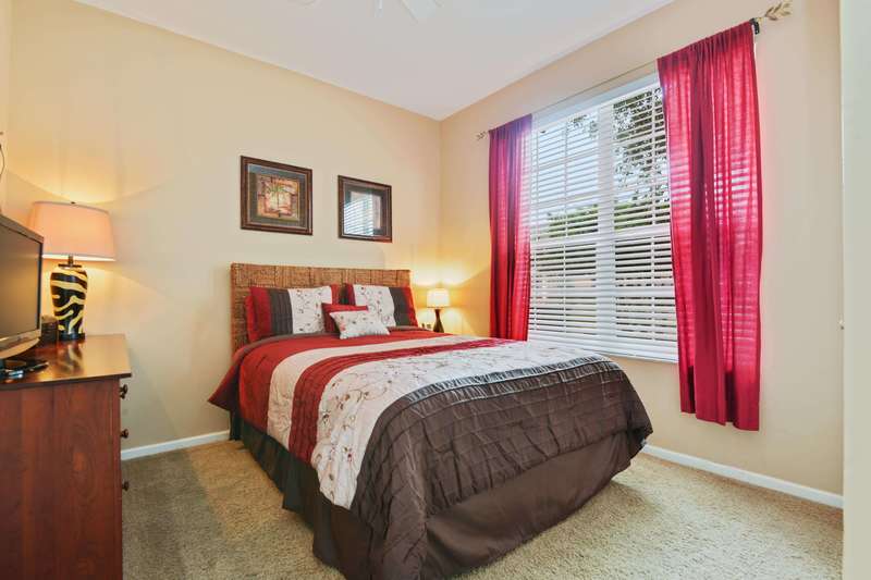 This queen bedroom offers space, comfort and privacy. Located off the hallways downstairs, this bedroom has a queen bed, dresser with flat-screen LCD TV, a ceiling fan, closet space, and an en-suite bathroom.